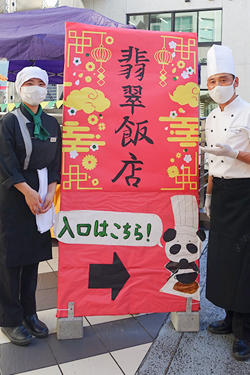 織田調理師専門学校の織田調祭の中国料理ブースに立つ教員と調理師科の学生